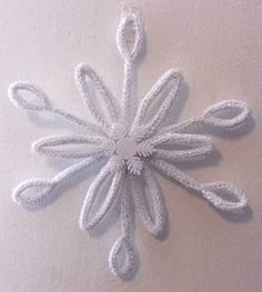 a crocheted snowflake hanging on the wall