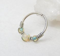 a silver ring with three opal beads on it