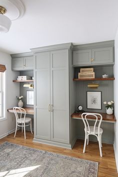 a room with gray cabinets and white chairs