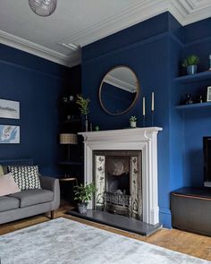 a living room with blue walls and a white fire place in the middle of it