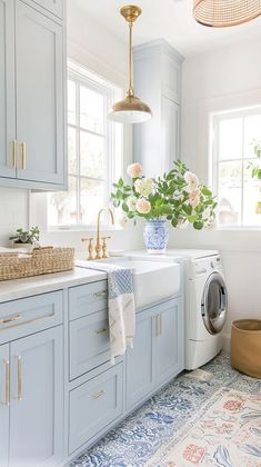 a washer and dryer in a kitchen with blue cabinets, white counter tops and gold accents