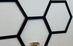 the wall is made up of black hexagons and gold knobs on it