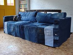 a couch made out of jeans sitting on top of a hard wood floor