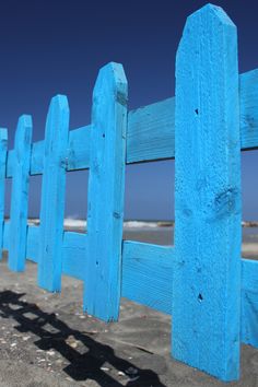 a blue wooden fence on the beach