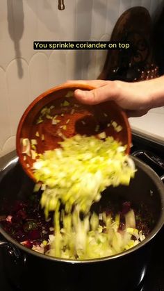 someone is stirring vegetables in a pot on the stove