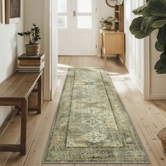 a hallway with a large rug on the floor and a plant in front of it