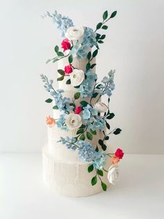 a wedding cake decorated with flowers and greenery