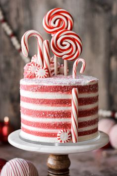 a red and white cake with candy canes on top