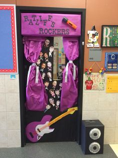 a door decorated with purple curtains and pictures on the front is an electric guitar that has been pinned to it