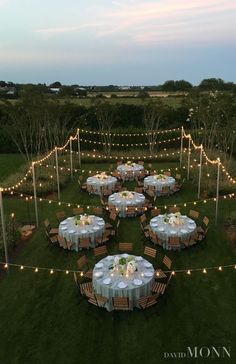 an aerial view of a table set up for a formal dinner in the middle of a field