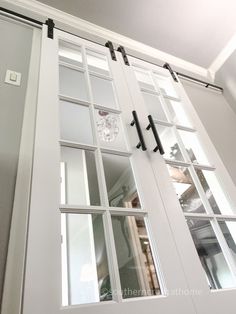 an open white door with glass panels and black handles