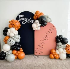 an arch decorated with balloons in the shape of bears and tigers is displayed on a carpeted floor