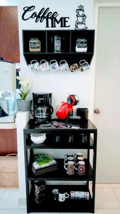 a coffee bar with cups and mugs on the shelves next to it is shown