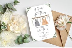 two dresses are hanging from a tree branch on the front of an envelope with flowers