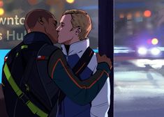 two men are hugging each other in front of a bus stop sign at night time