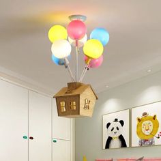 a child's bedroom with balloons and a birdhouse hanging from the light fixture