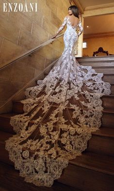 a woman is walking down the stairs in a wedding dress with an open back and long sleeves