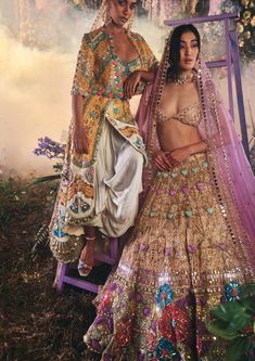 Editor's Note Featuring a 4-piece bridal lehenga set in dreamy pink and ivory tulle is embroidered using glass cut crystals, 3d hearts, and multi-coloured floral appliqués. It is paired with a blush tulle blouse embroidered with zari and pearl detailing. This look is completed with an all gold embroidered tissue organza side dupatta and a lilac organza head dupatta. Color: Pink, ivory Fabric: Tulle, organza Sleeve type: Half Neckline: Sweetheart Embroidery details: glass cut crystals, 3d hearts, Luxury Multicolor Hand Embellished Lehenga, Luxury Embroidered Multicolor Lehenga, Multicolor Organza Lehenga With Intricate Embroidery, Elegant Pink Embroidered Lehenga, Pink Embroidered Lehenga, Pink Bridal Lehenga, Baju Kahwin, Tulle Blouse, Image Swag