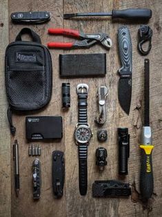 the contents of a survival kit laid out on a wooden table with tools and gadgets