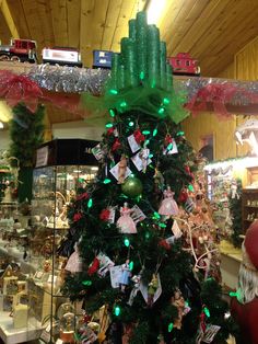 a christmas tree with green lights and pictures on it in a store ornament