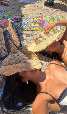 a woman laying on the ground with two hats over her head and one hat in front of her face