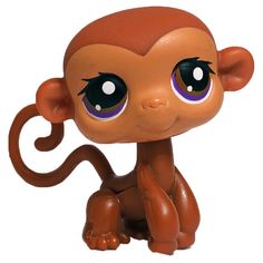 a little monkey with big eyes sitting on top of a white surface and looking at the camera