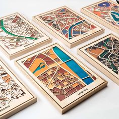 six wooden coasters with different colored maps on them, all showing roads and streets