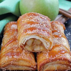 apple turnovers with powdered sugar on top and an apple in the background next to them