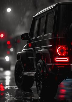 a black and red jeep parked in the rain