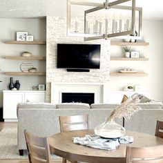 a living room filled with furniture and a flat screen tv mounted on the wall above a fireplace