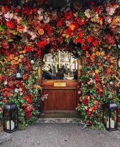 an entrance to a building covered in flowers