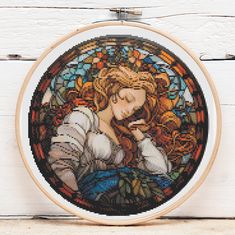 a cross stitched picture of a woman holding a cell phone