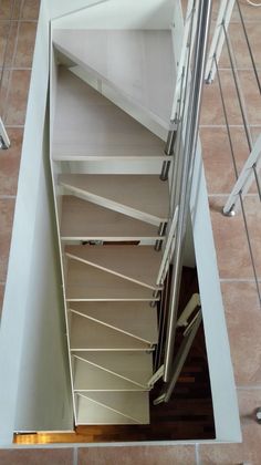 an overhead view of a stair case in a house with tile flooring and white walls