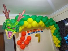 the balloon arch is decorated with an image of a dragon and number one on it