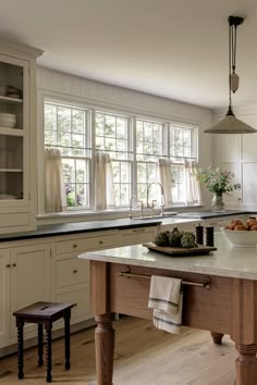 a kitchen with white cabinets and an island in the middle of the room is shown