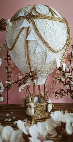 a hot air balloon sitting on top of a wooden table next to flowers and branches