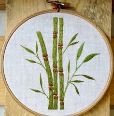 a close up of a embroidery on a piece of wood with bamboo sticks in it