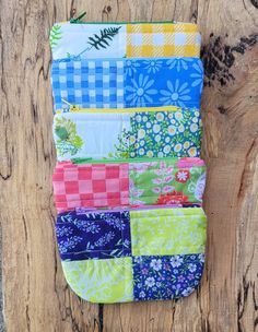 a multicolored patchwork pouch hanging on a wooden wall with wood planks in the background