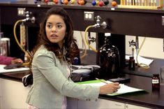 a woman standing in front of a counter holding a pen and paper