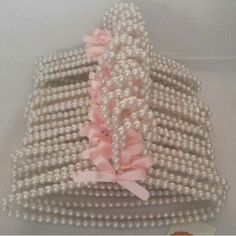 a bunch of pearls are stacked on top of each other with pink ribbons and bows