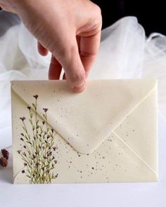 a person is opening an envelope with flowers on it