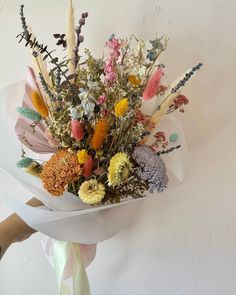 a person holding a bouquet of flowers in their hand