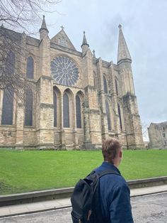 a man with a backpack is looking at an old church