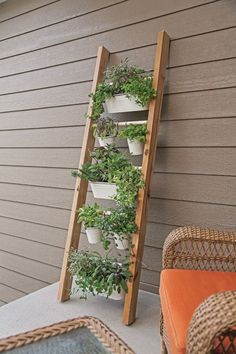 a wooden ladder is holding plants on the side of a house with potted plants