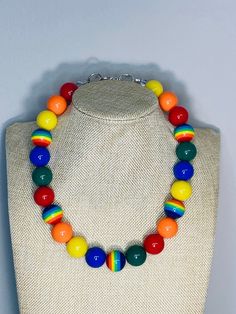 a multicolored necklace is displayed on a mannequin