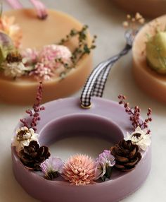 three cakes decorated with flowers and pine cones