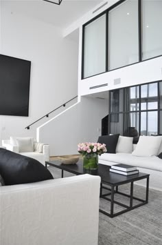 a living room filled with white furniture and lots of windows