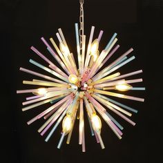 a multi - colored chandelier hanging from a chain on a black background,