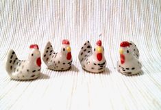 four small ceramic chickens sitting next to each other