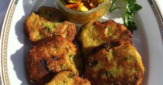 some food is sitting on a plate next to a bowl of vegetables and dipping sauce